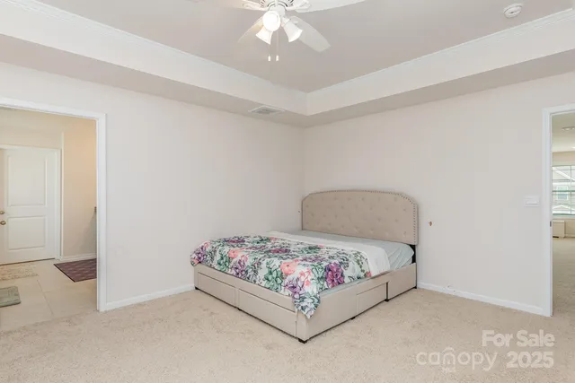 a bedroom with a bed and a chandelier fan