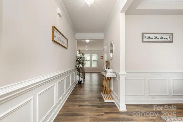 a view of a hallway with wooden floor and staircase