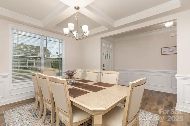 a view of a dining room with furniture a chandelier and wooden floor