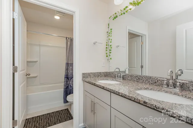 a bathroom with a granite countertop sink a mirror and a shower