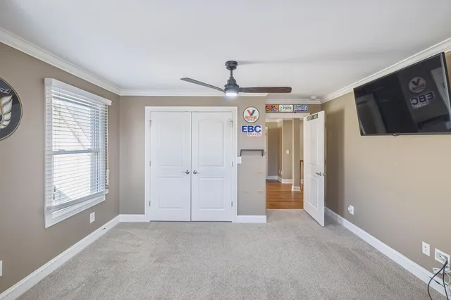 a view of empty room with window and ceiling fan