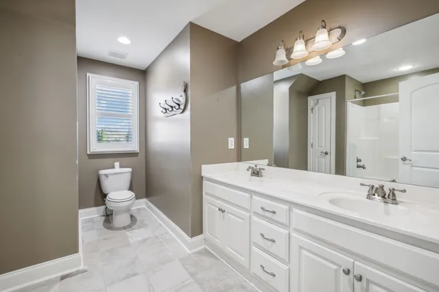 a spacious bathroom with a double vanity sink mirror and toilet