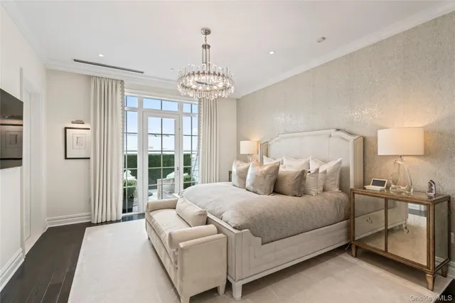 a bedroom with a large bed and a chandelier