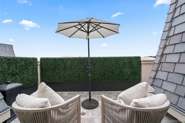 a view of a roof deck with table and chairs