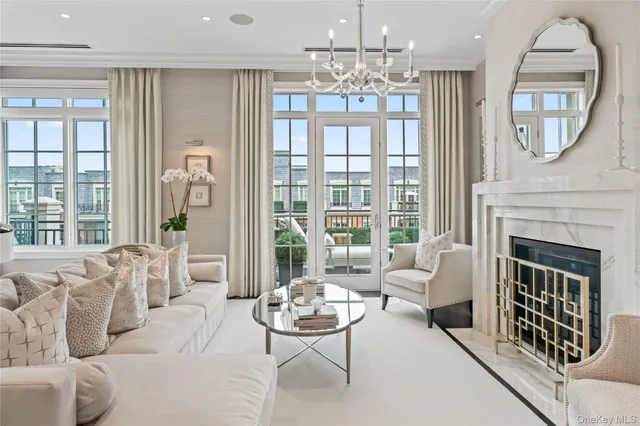 a living room with furniture a fireplace and a chandelier