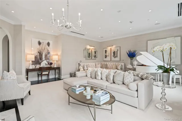 a living room with furniture and a chandelier