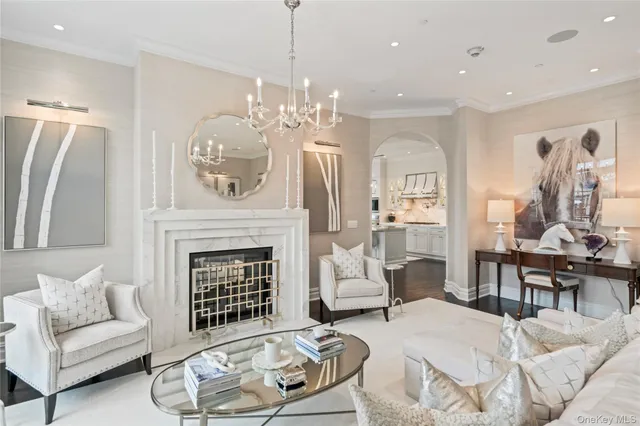 a living room with furniture a fireplace and chandelier
