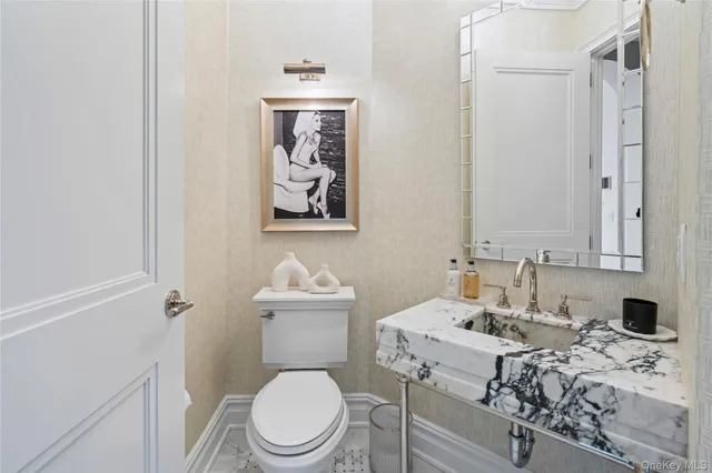 a bathroom with a toilet sink and mirror