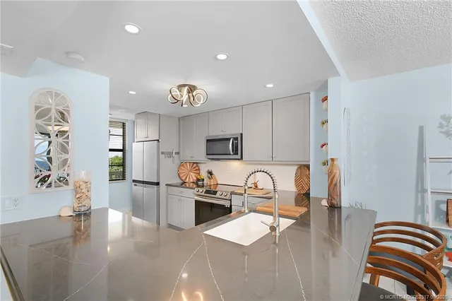 a kitchen with stainless steel appliances granite countertop a sink and stove