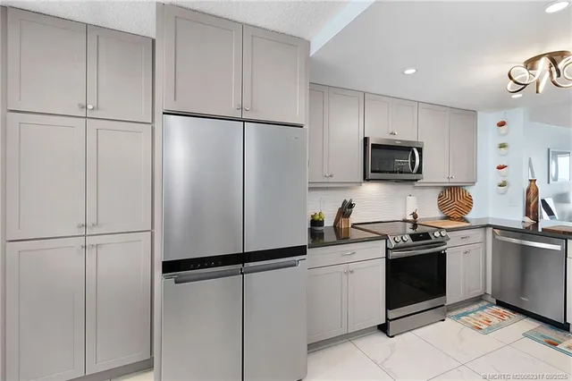 a kitchen with cabinets stainless steel appliances and a refrigerator