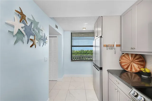 a kitchen with stainless steel appliances granite countertop a refrigerator and a stove