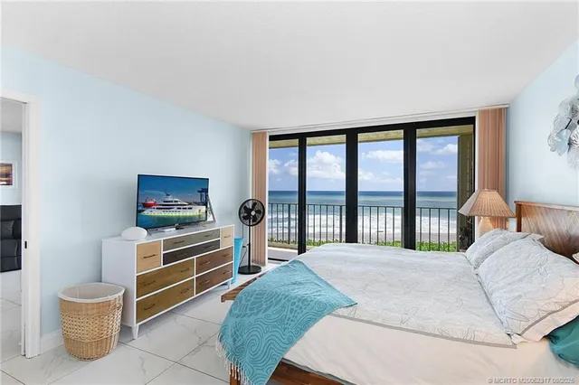 a bedroom with a bed and a flat tv screen next to a window