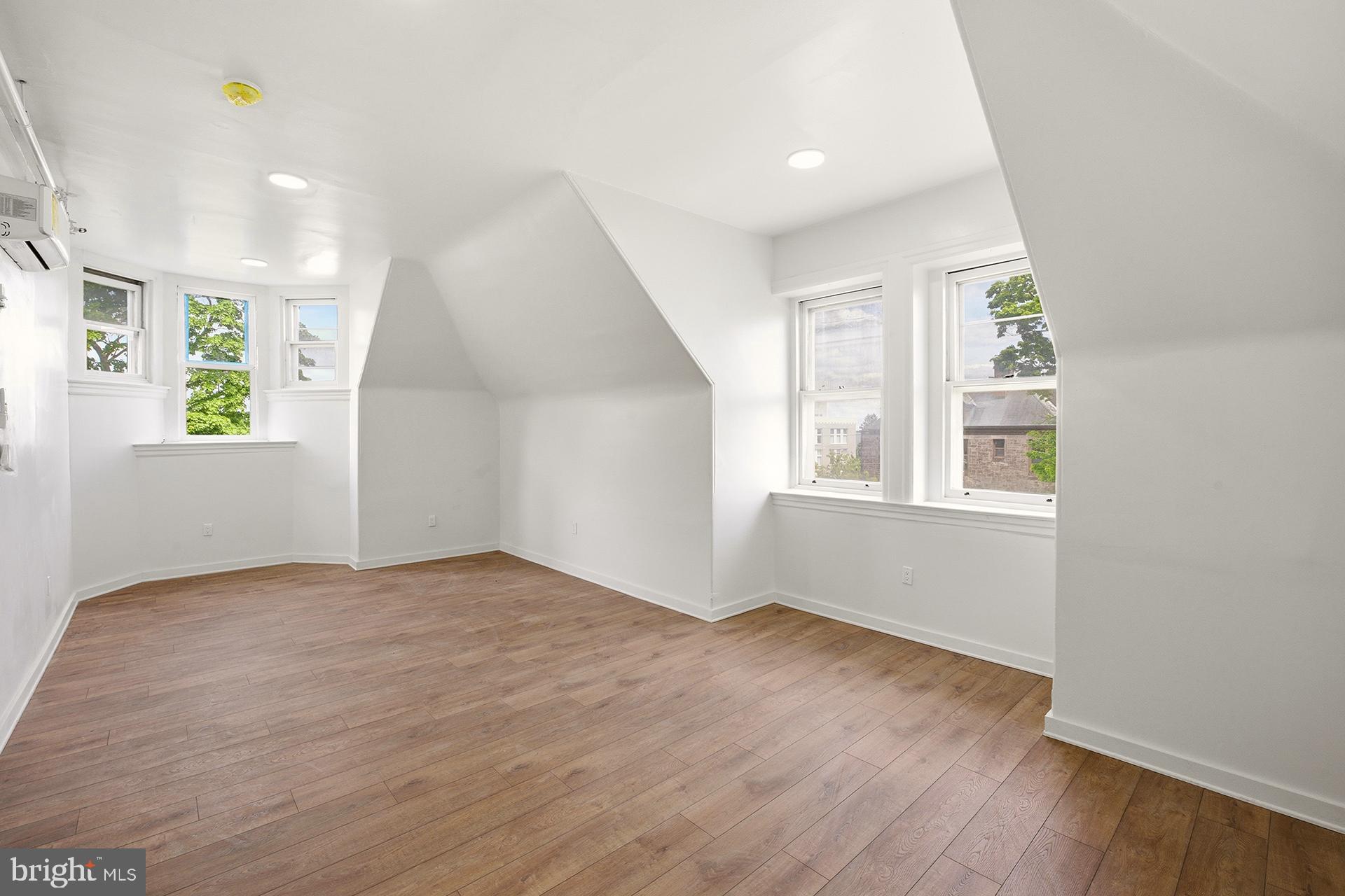 6012 Ridge Avenue, Unit 7 Philadelphia, PA 19128 - Photo 12 of 17 a view of an empty room with wooden floor and a window