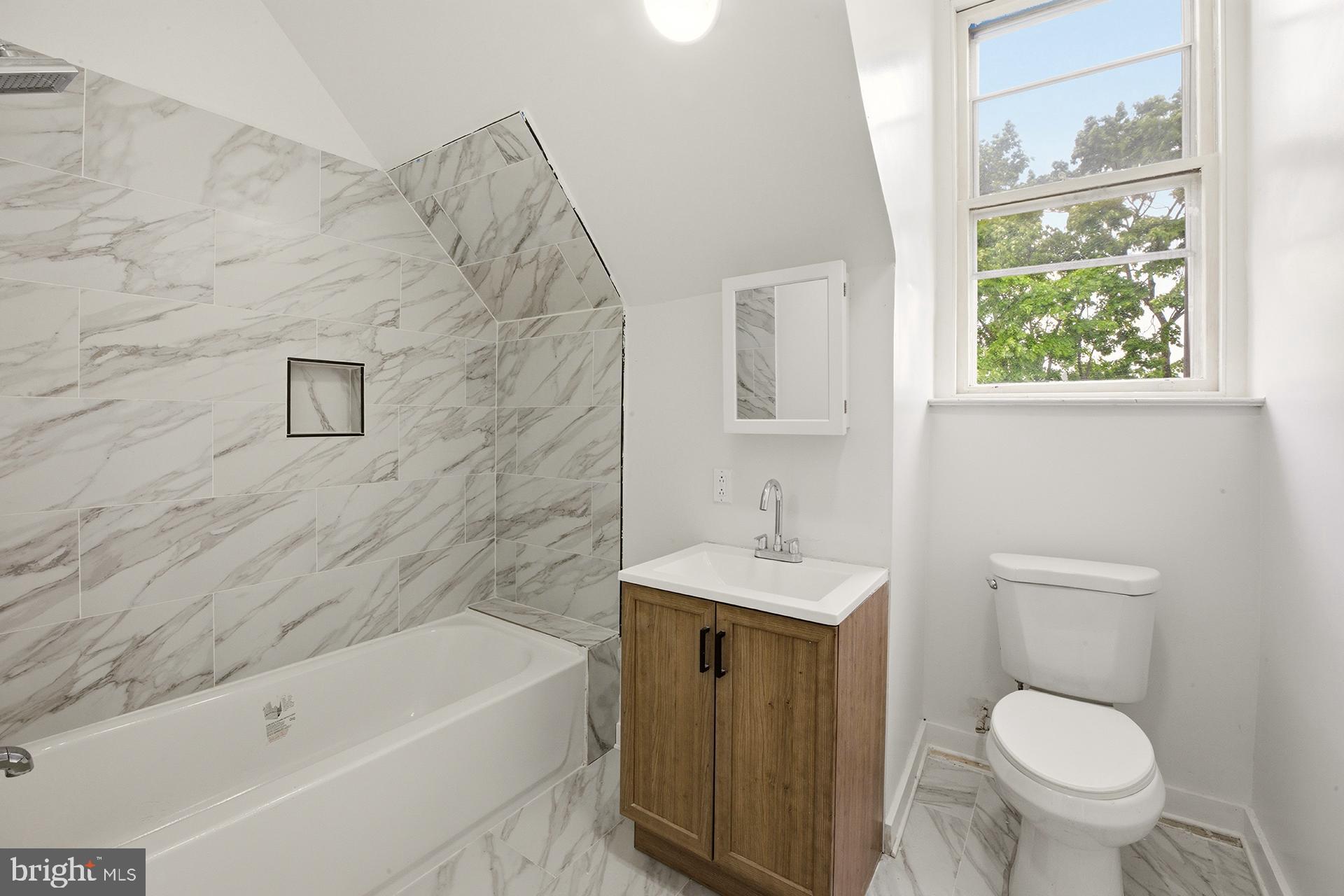 6012 Ridge Avenue, Unit 7 Philadelphia, PA 19128 - Photo 7 of 17 a bathroom with a toilet a sink and bathtub