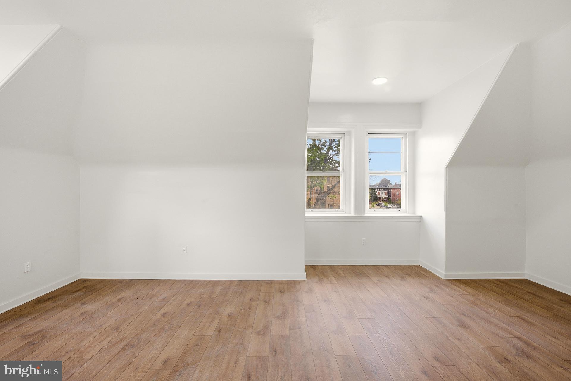 6012 Ridge Avenue, Unit 7 Philadelphia, PA 19128 - Photo 10 of 17 an empty room with wooden floor and windows