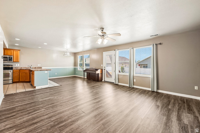 3215 West 450 North West Point, UT 84015 - Photo 6 of 40 Open-concept living area featuring wood-finish flooring, a ceiling fan, and multiple windows with blinds