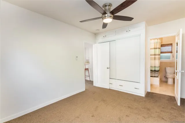 a kitchen with stainless steel appliances granite countertop a stove a sink dishwasher a refrigerator with white cabinets and wooden floor