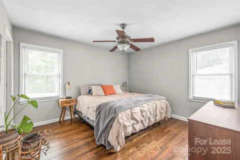 a bedroom with a bed chandelier and a window