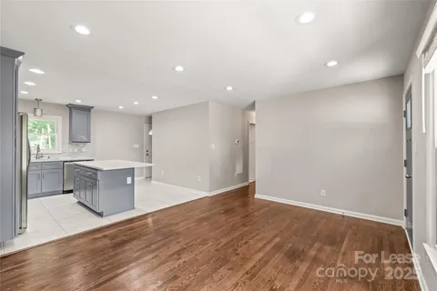 a view of kitchen with kitchen island wooden floor center island and stainless steel appliances