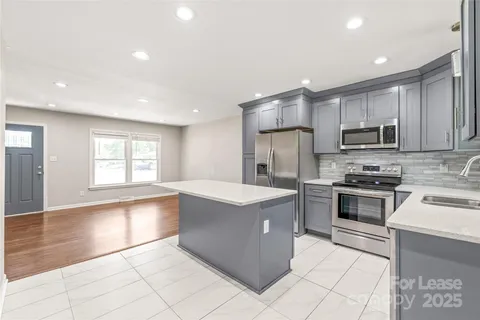 a large kitchen with stainless steel appliances granite countertop a stove and a sink