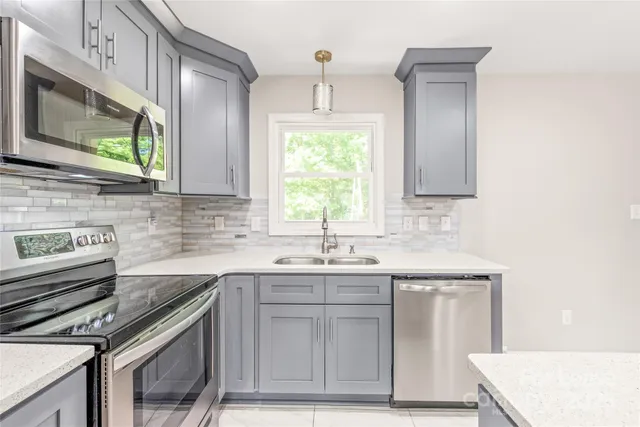 a kitchen with stainless steel appliances granite countertop a sink stove and microwave