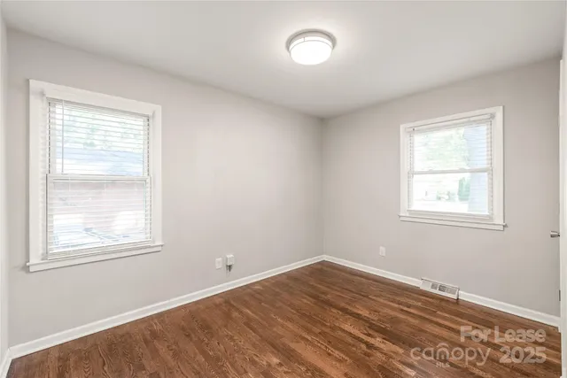 a view of a room with wooden floor and windows