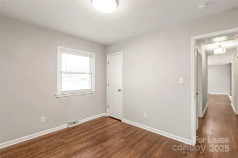 an empty room with wooden floor and a window