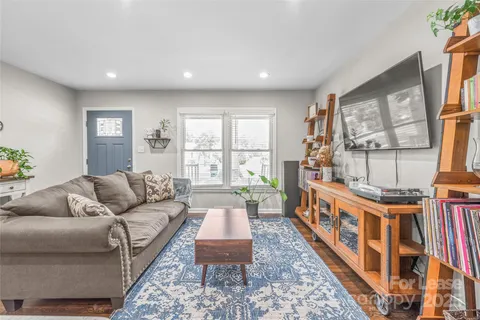 a living room with furniture wooden floor and a large window