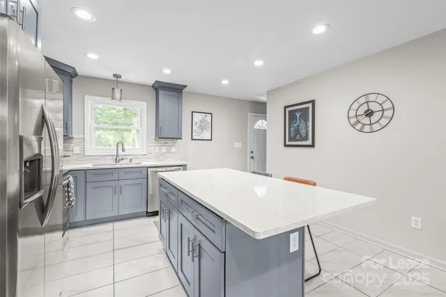 a kitchen with a refrigerator a sink and cabinets