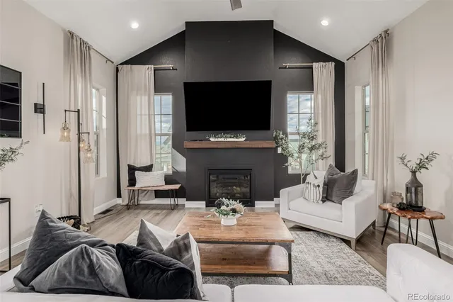 a living room with furniture a flat screen tv and a fireplace