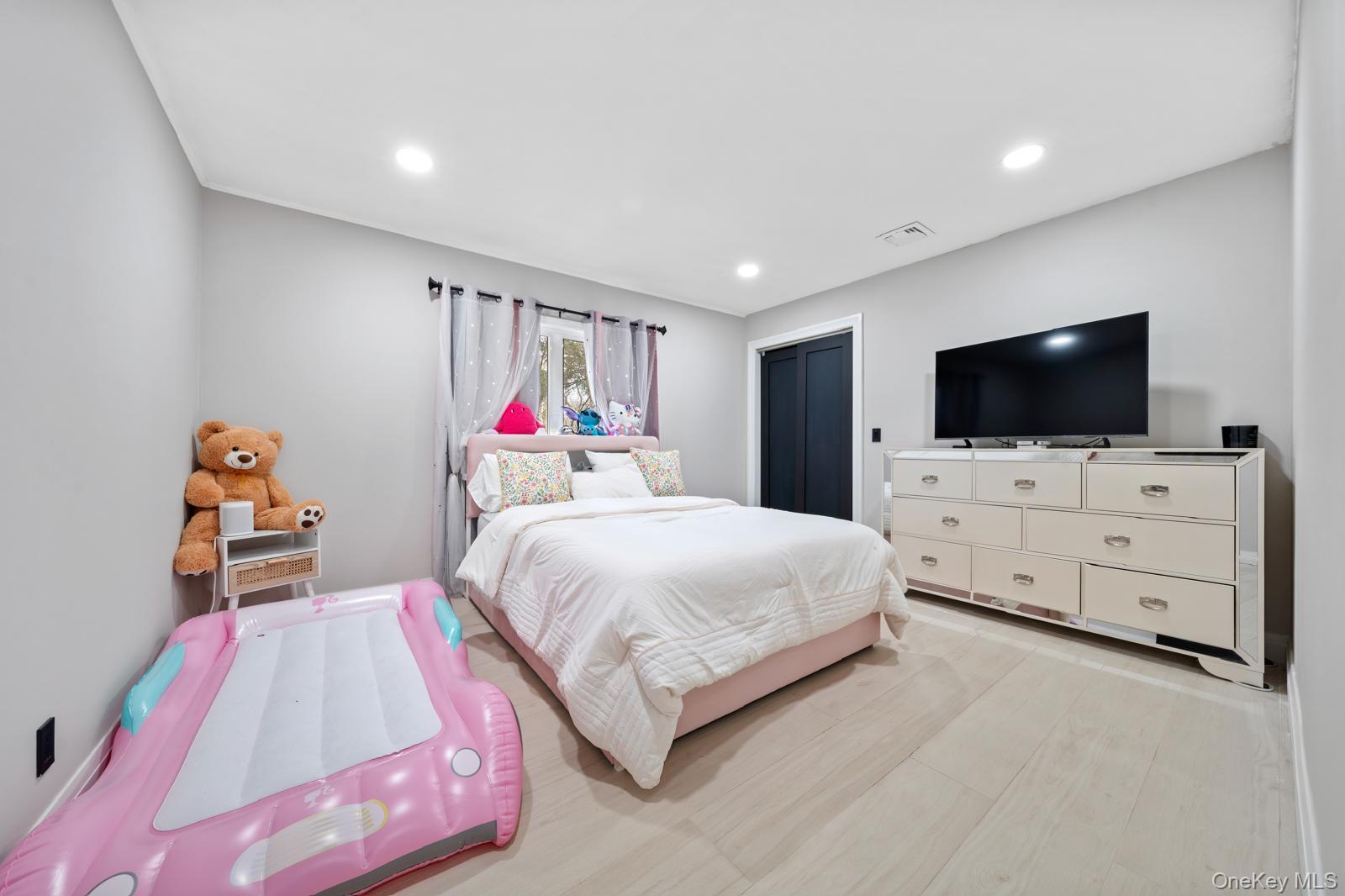 111 Mill River Road Oyster Bay, NY 11771 - Photo 19 of 48 a bedroom with a bed and a flat screen tv