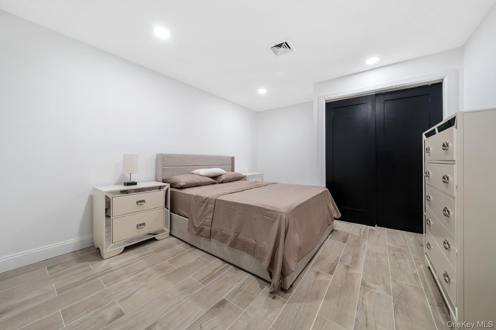 111 Mill River Road Oyster Bay, NY 11771 - Photo 34 of 48 a bedroom with a bed and a flat screen tv