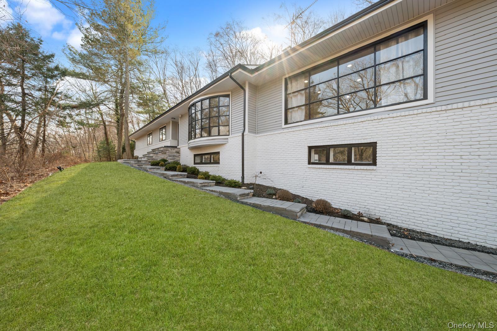 111 Mill River Road Oyster Bay, NY 11771 - Photo 7 of 48 a backyard of a house with lots of green space and outdoor seating