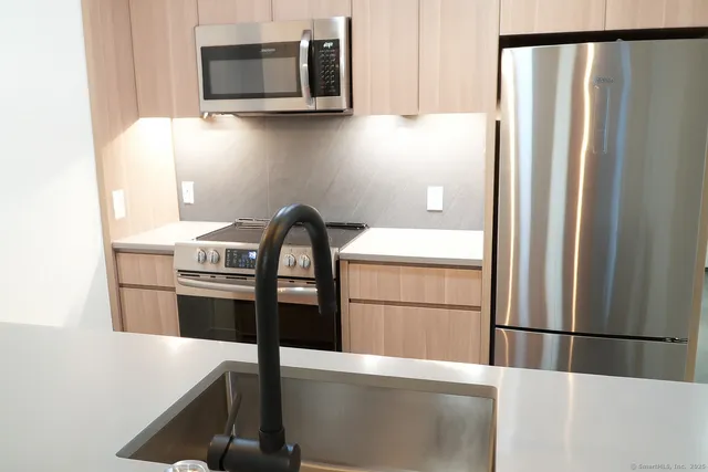 a kitchen with stainless steel appliances a refrigerator and a stove top oven