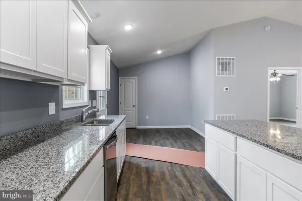 a kitchen with stainless steel appliances granite countertop a sink a stove a refrigerator and cabinets