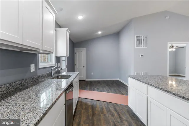 a kitchen with stainless steel appliances granite countertop a sink a stove a refrigerator and cabinets