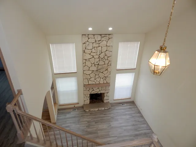 a view of a livingroom with wooden floor and staircase