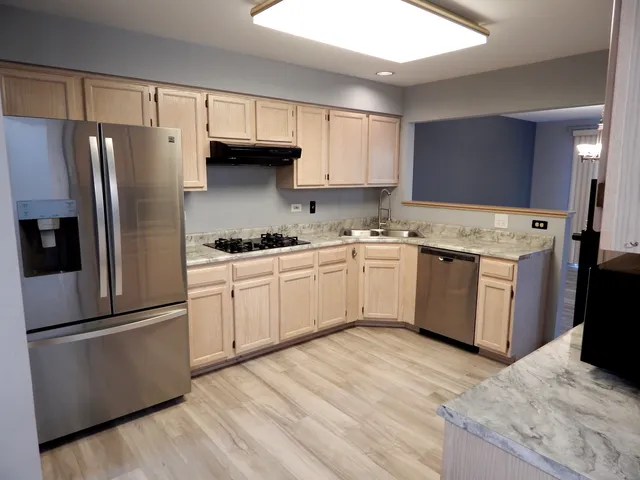 a kitchen with a refrigerator sink and cabinets