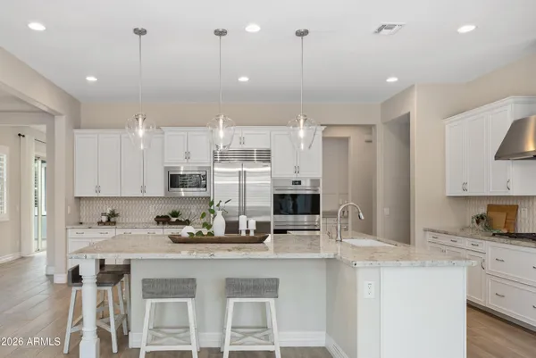 a kitchen with stainless steel appliances granite countertop a sink refrigerator and cabinets
