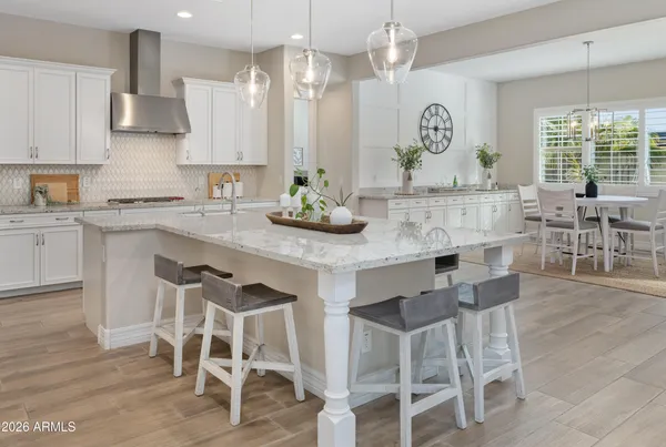 a kitchen with stainless steel appliances kitchen island a table and chairs in it