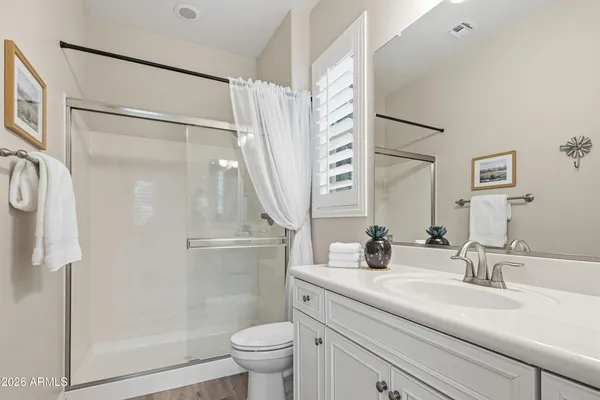 a bathroom with a double vanity sink toilet and shower