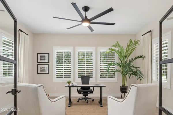 a living room with furniture a potted plant and a large window