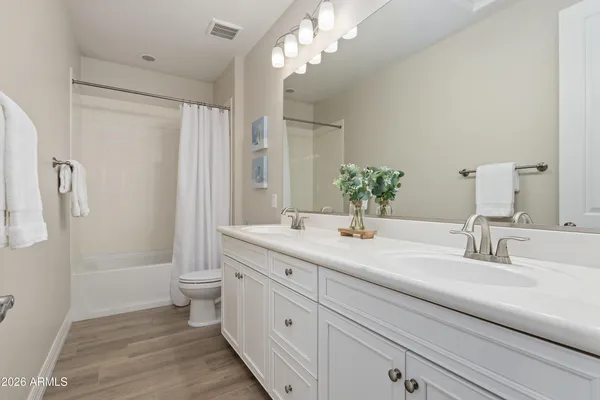a bathroom with a double vanity sink toilet and shower