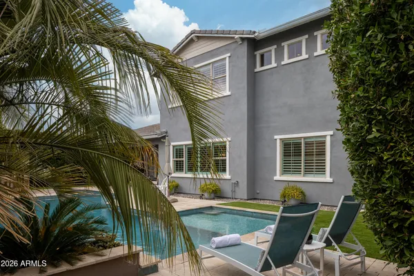 a outdoor space with the couches and dining table with potted plants