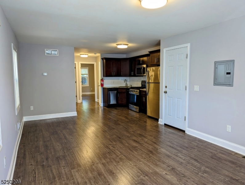 116 Maple Avenue, Unit 1 Montclair, NJ 07042 - Photo 3 of 7 an empty room with wooden floor and a kitchen