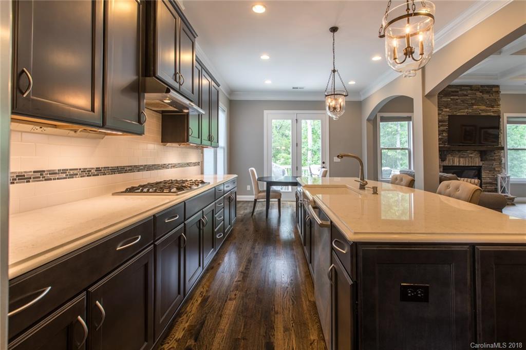 8053 Clems Branch Road Indian Land, SC 29707 - Photo 8 of 25 a kitchen with stainless steel appliances granite countertop a sink a stove and a wooden floors