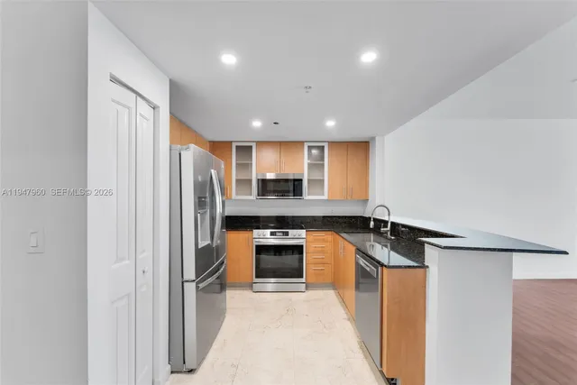 a large kitchen with stainless steel appliances granite countertop a stove and a wooden floors