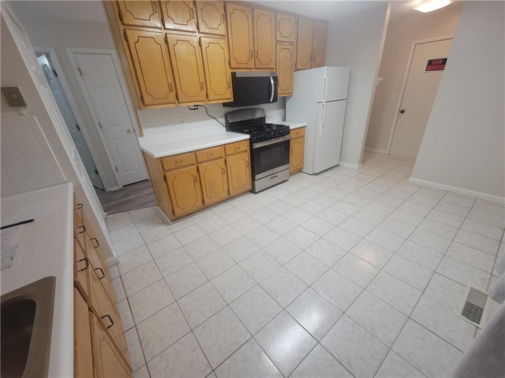 1326 Lori Court Conley, GA 30288 - Photo 11 of 15 a kitchen with a refrigerator stove and white cabinets