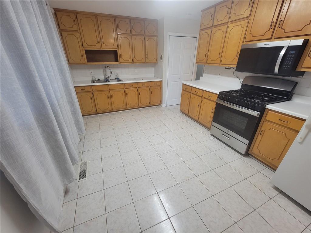 1326 Lori Court Conley, GA 30288 - Photo 10 of 15 a kitchen with stainless steel appliances a stove a sink and a refrigerator