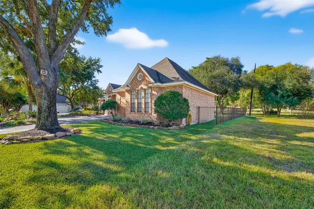 a view of a house with a big yard and palm trees